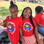 2 teens showing off their t-shirts