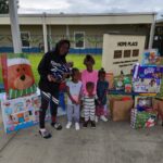 A group of children posing outside Hope Place with donated goods
