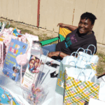 Founder sitting at a table with Easter supplies smiling