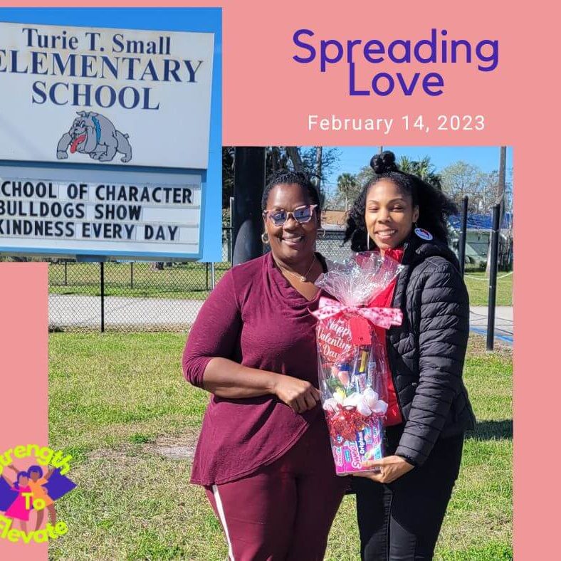 Happy Valentines Day at Turie T. Small Elementary School. Two adults holding a gift basket. Happy Valentines Day at Turie T. Small Elementary School. Two adults holding a gift basket.